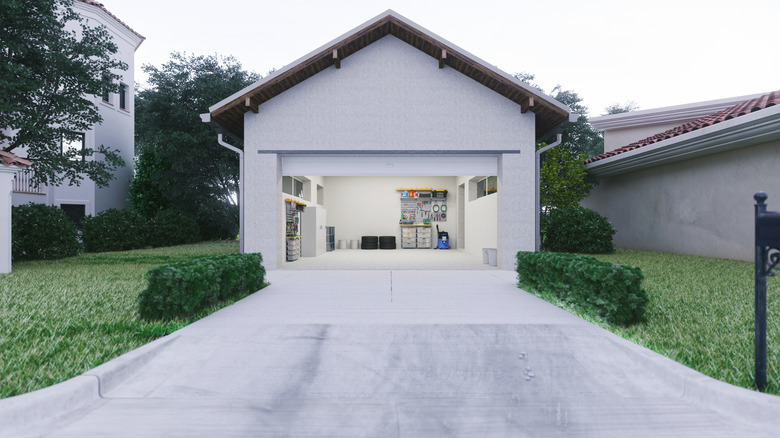 A concrete driveway leading to a garage with an open garage door