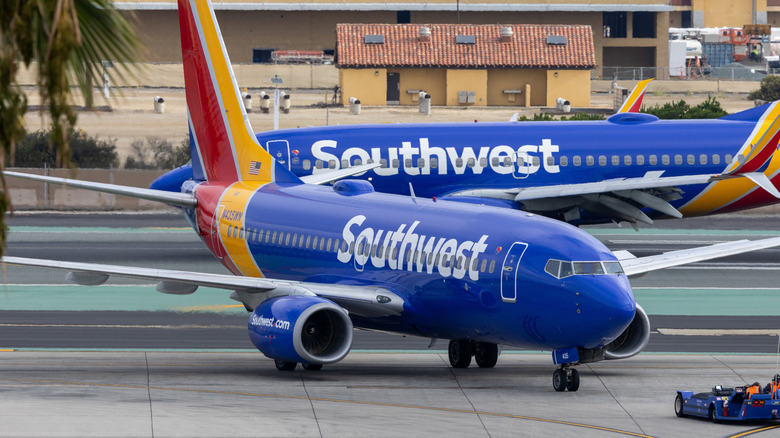A Southwest Airlines-branded Boeing 737-700, front 3/4 view, another Southwest airliner in the background
