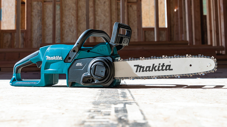 Makita 18V LXT 14-inch chainsaw on the ground in a partially constructed building