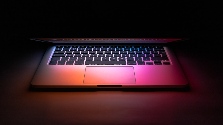 half shut MacBook orange pink light