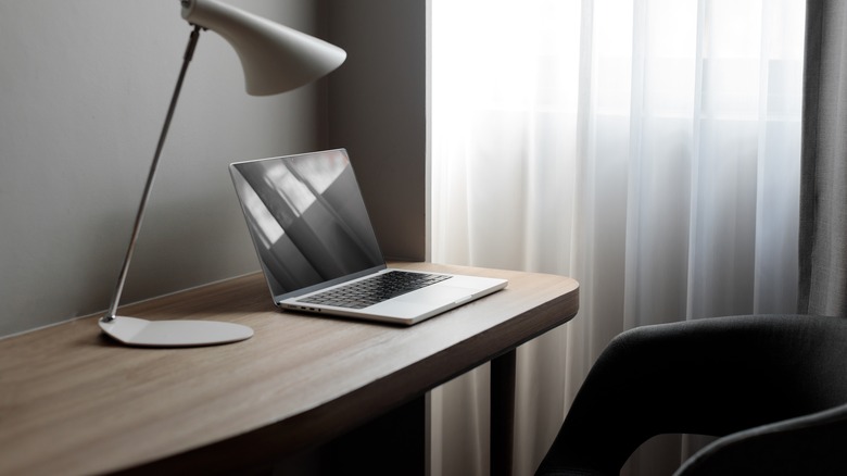 Macbook on desk near lamp