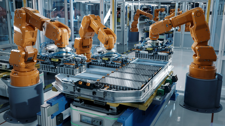 Robotic arms assembling EV batteries in a factory