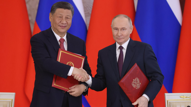 Xi Jinping and Vladimir Putin shake hands at Russia's May 2025 Victory Day celebrations, a visit in which the two nations released a joint statement condemning the Golden Dome.