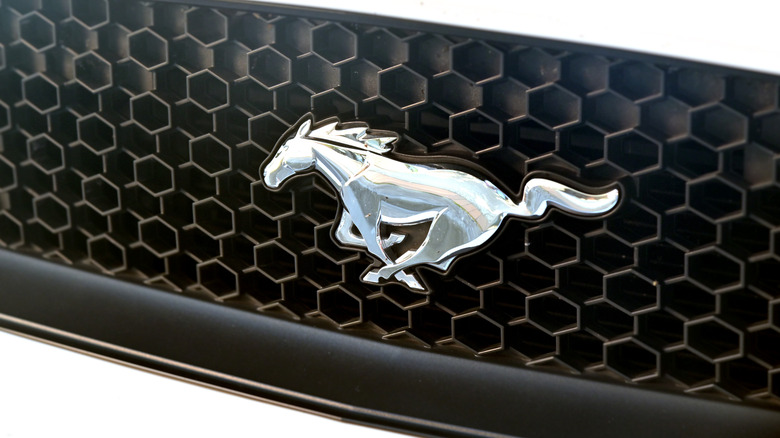 The Mustang galloping horse logo on the grille of an unknown Mustang generation