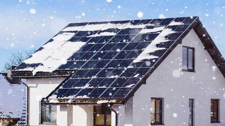 Solar panels on a house roof with snow.