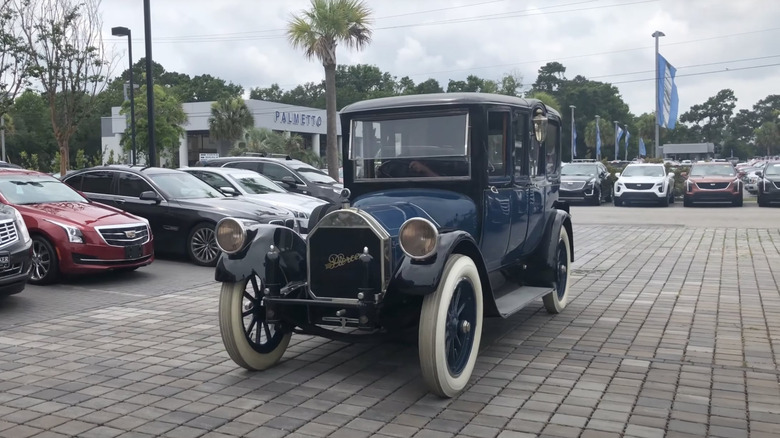 A 1919 Pierce-Arrow Model 31 at a car dealership, front 3/4 view, blue and black exterior