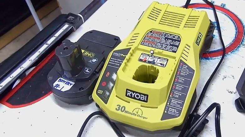 A Ryobi nickel-cadmium battery beside a charger