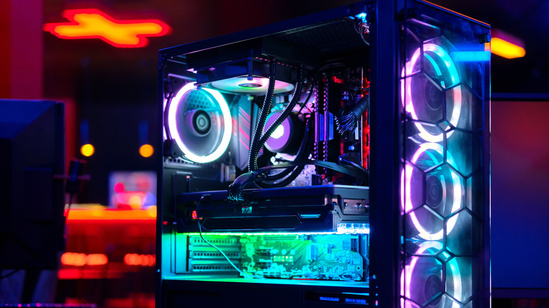A desktop computer lit up with many colors, RGB fans, AIO cooling, with side panel down