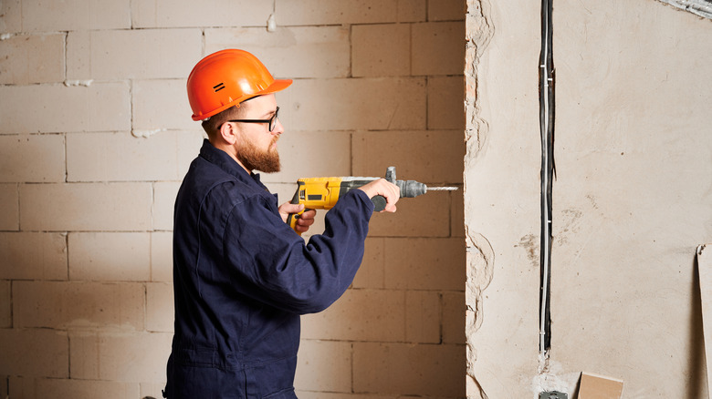 A worker drilling into concrete