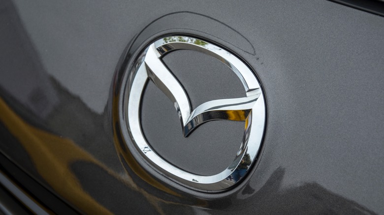 Close-up of the Mazda emblem on a dark gray car