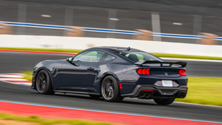 Rear 3/4 view of 2024 Ford Mustang Dark Horse on the move on a race track