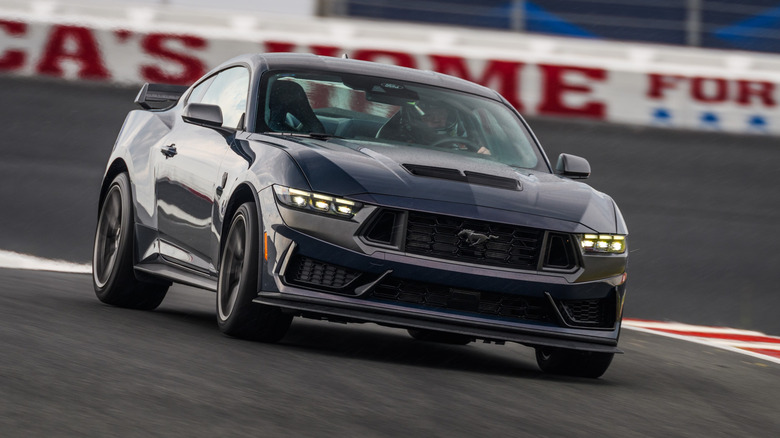 Ford Mustang Dark Horse on the move on a race track, front 3/4 view