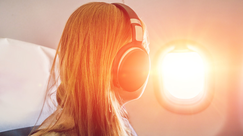 Person in headphones looking out of a United Airlines plane window