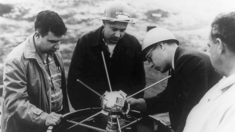 Engineers placing the Vanguard I satellite on top of its launch vehicle