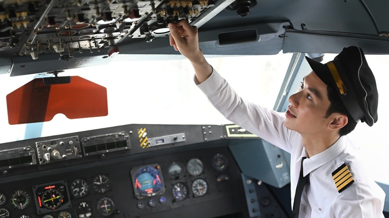 Pilot pulling switch in cockpit