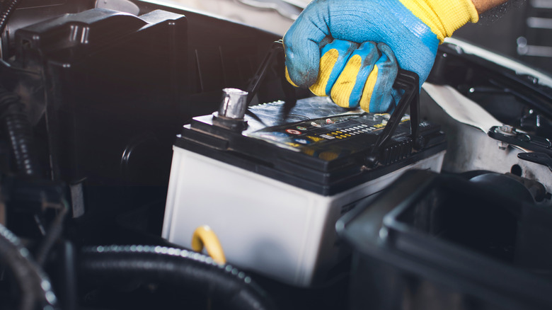 Person removing car battery from a car