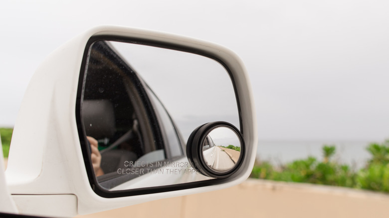 Car Side Mirror View of Tropical Travel on a Sea-Side Road in Palm Beach, Florida.