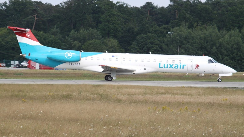 An Embraer ERJ-145 aircraft sitting on the runway stationary