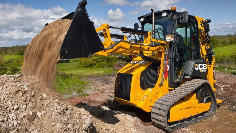 JCB 1CXT using the front loader bucket to move dirt and rocks