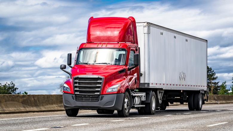 Red semitruck cab pulling white trailer