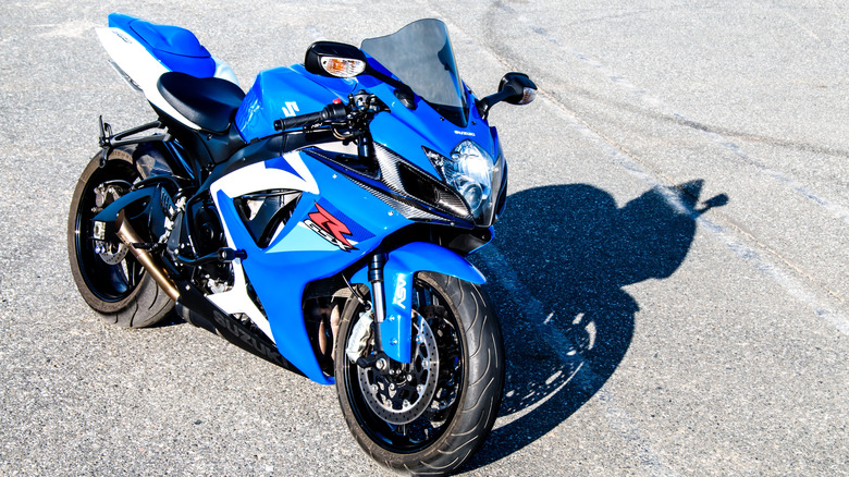 A bright blue Suzuki GSX-R750 parked in harsh sunlight