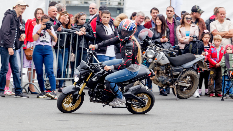 riding honda grom in front crowd