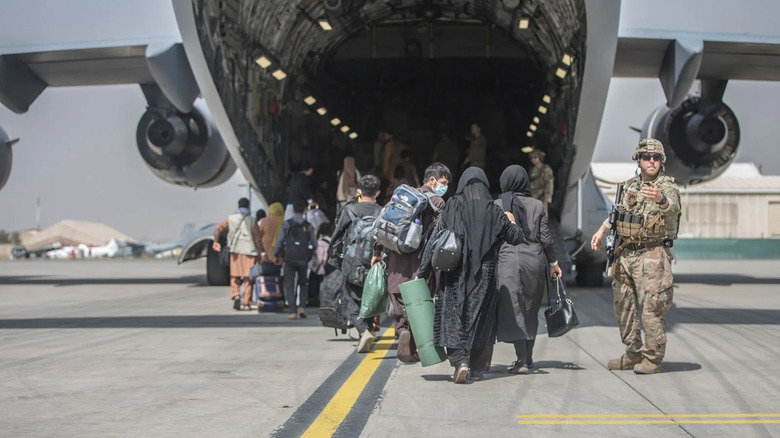Families board U.S. Air Force aircraft during the evacuation of Kabul