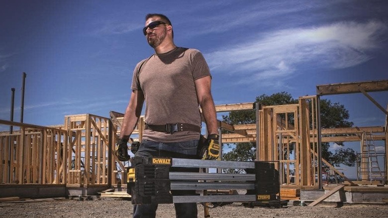 man carrying DEWALT Folding Workbench