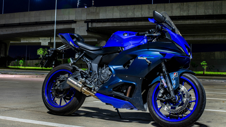 A tuned blue Yamaha R7 parked in a parking lot at night