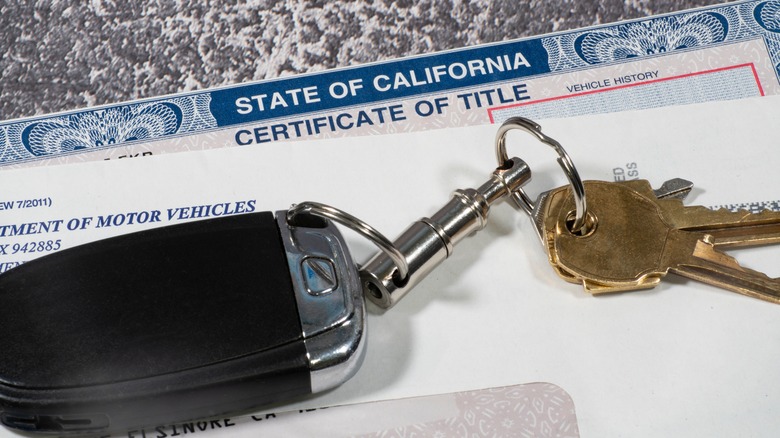 Set of car keys sitting on top of a Californian vehicle registration document