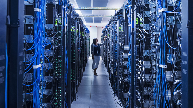 A woman in a big data center with multiple cables