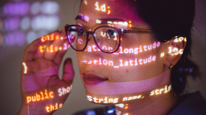 portrait of female programmer with program code projected on her face