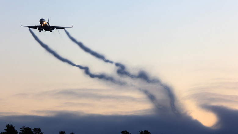 Plane taking off trailing wake turbulence vortices behind it