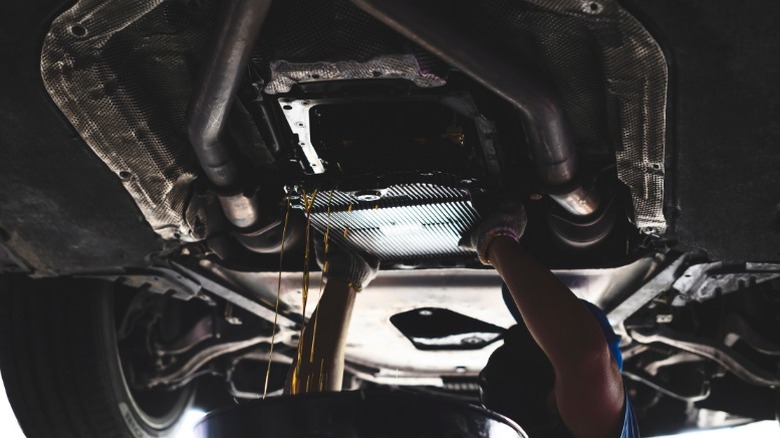 A mechanic removing the transmission fluid pan during a transmission fluid service