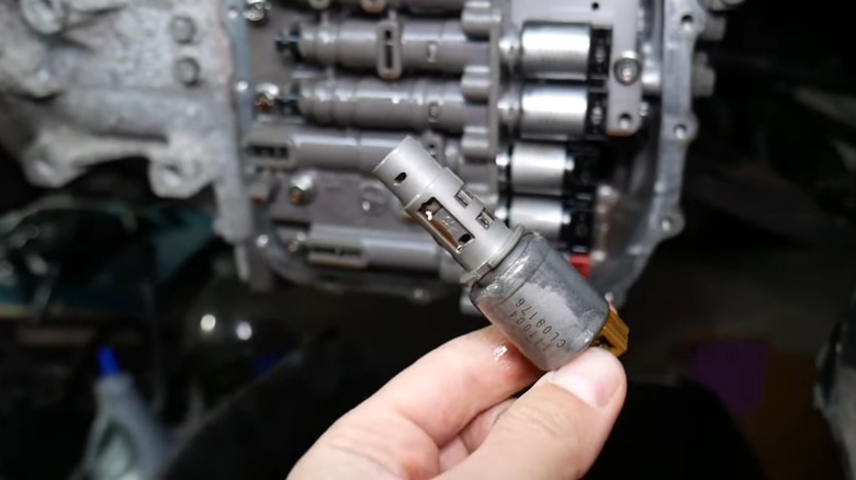 A person holding a used transmission solenoid