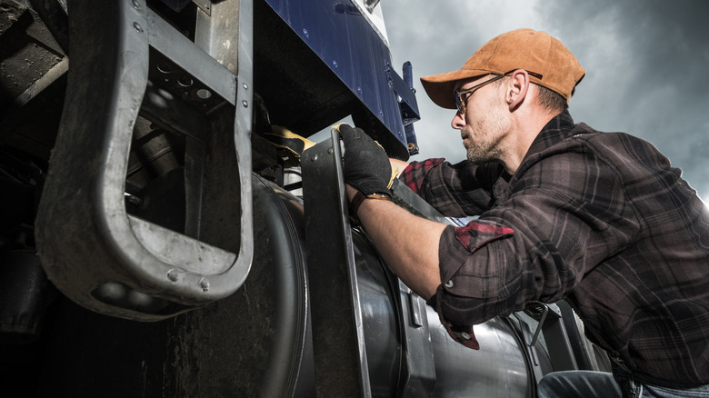 Semi truck driver carrying out a pre-inspection