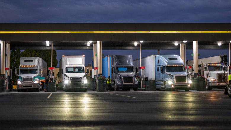 Semi trucks filling with fuel at a truck stop
