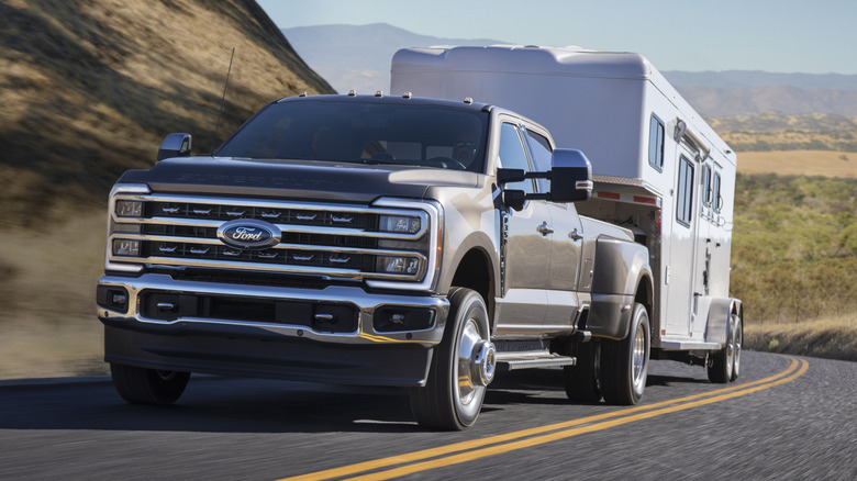 Ford F-350 Super Duty viewed from front left towing trailer up hill