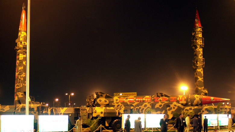 3D render of short-range tactical warheads mounted on MLRS wheeled platform with Pakistan flag in background
