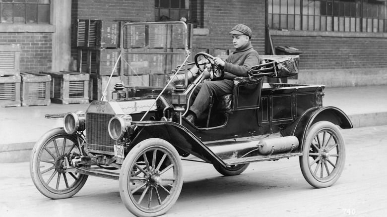 Ford Model T driving down road, original black & white photograph, front-left three-quarter view