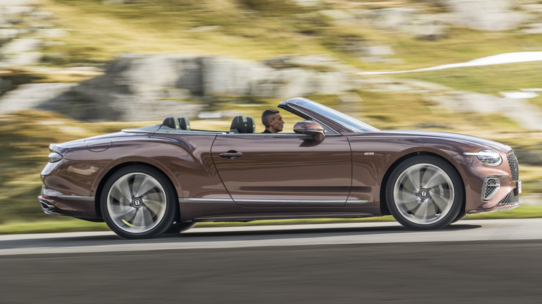 Man driving rose gold 2016 Bentley Continental GTC convertible with top down