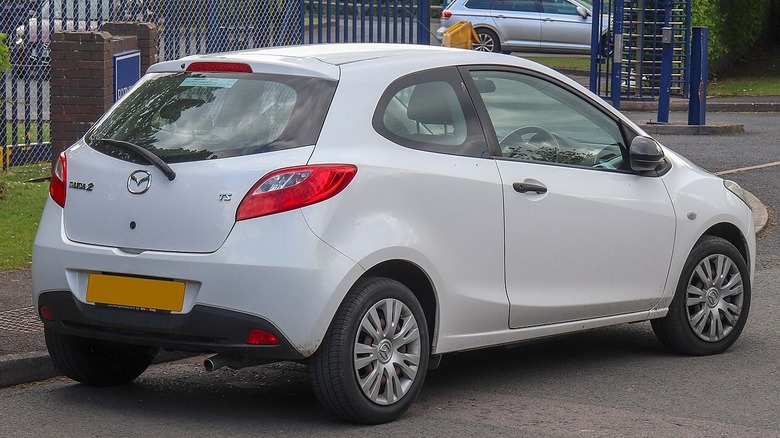 White 2009 Mazda2 TS parked near city playground