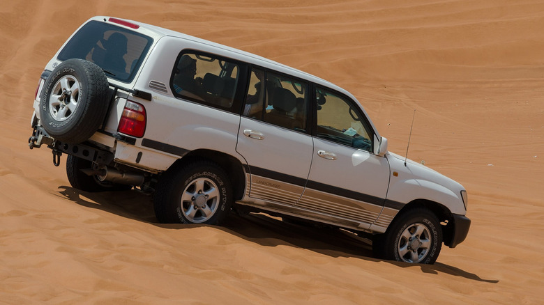 Rear 3/4 view of a 100 Series Land Cruiser in the desert
