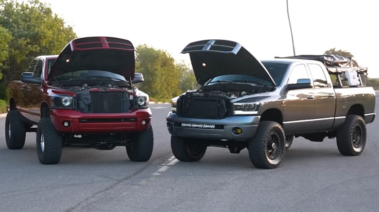 Front profile view of third generation 5.9L (right) and 6.7L (left) Cummins trucks parked side by side
