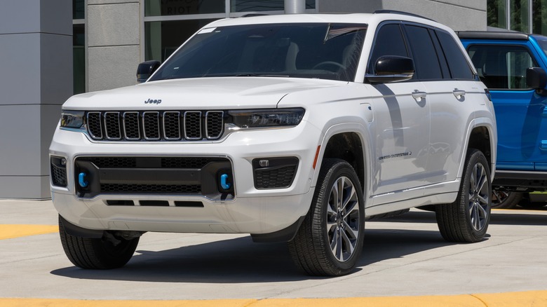 A white Jeep Grand Cherokee Overland 4xe hybrid on display.