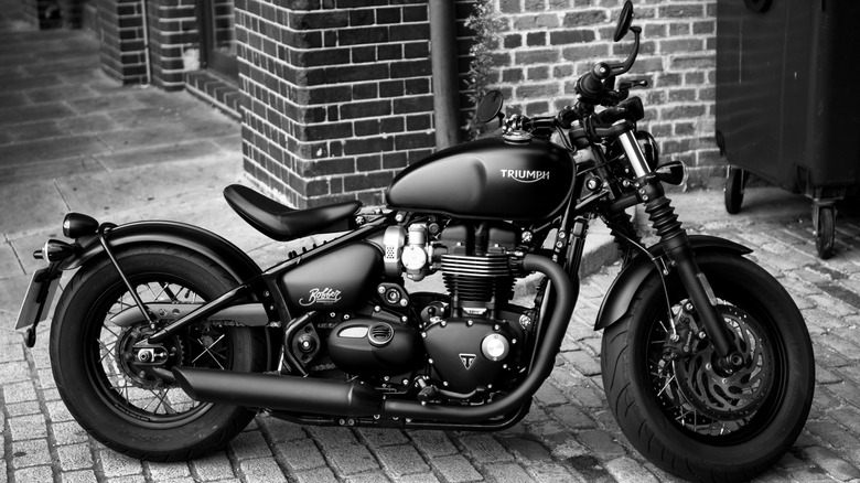 A grayscale shot of a parked Triumph Bonneville Bobber Motorcycle