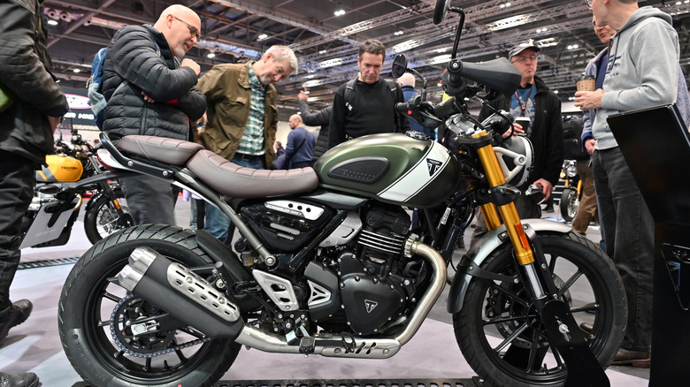Men looking at Triumph Scrambler 400 X motorcycle on display