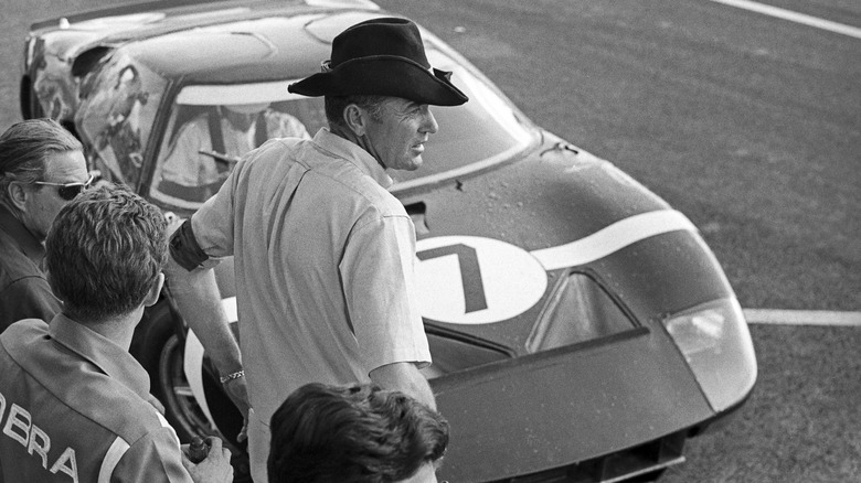 Carroll Shelby standing in front of a Ford GT40 on a race track