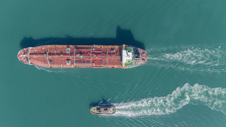 Ariel view of a large cargo ship besides a small boat