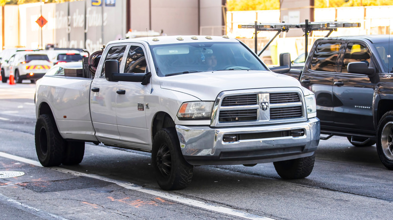 White dually Ram truck sitting in traffic on a city street